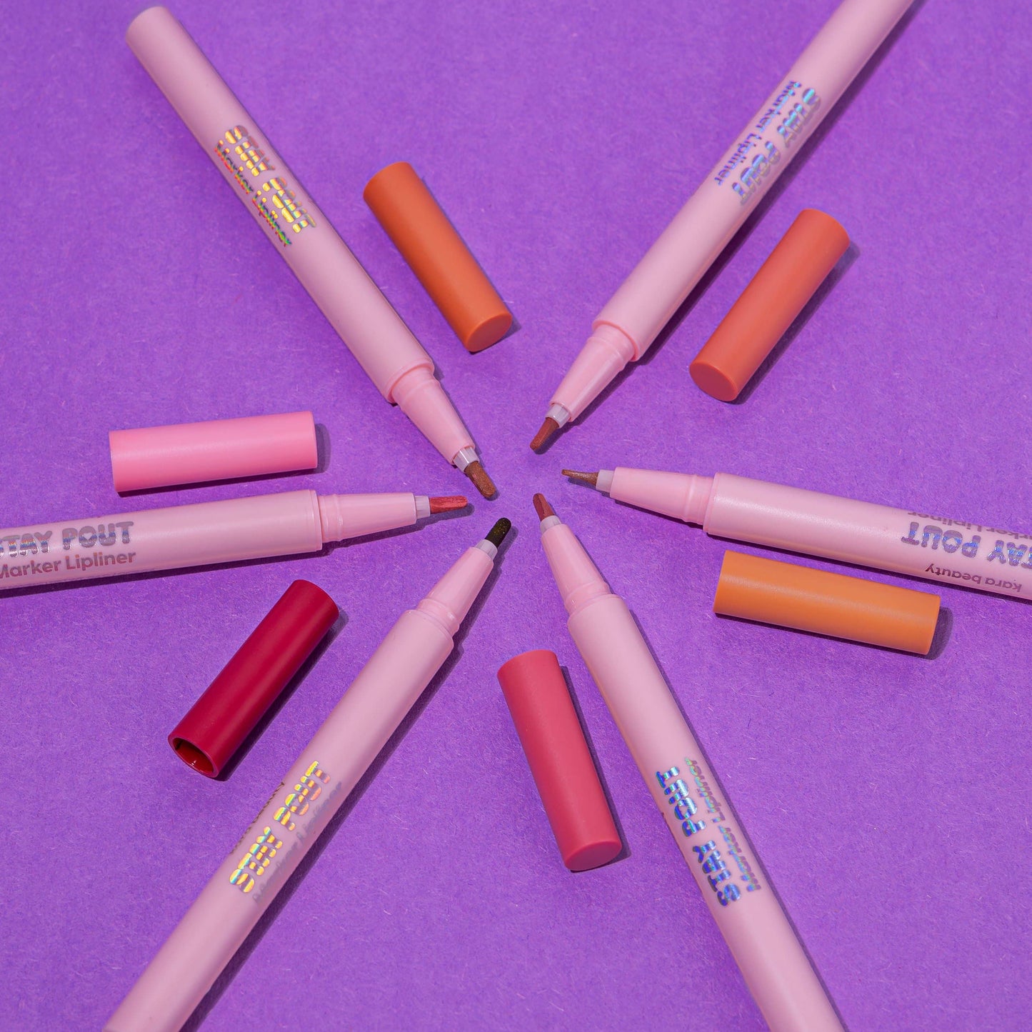rosewood lip marker pens arranged in a circle on purple background showing shades and fine marker tips