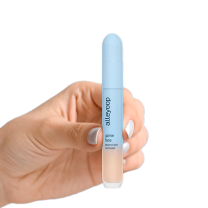 Hand holding Alleyoop Game Face Concealer by Innovate the Label in light blue sleek packaging
