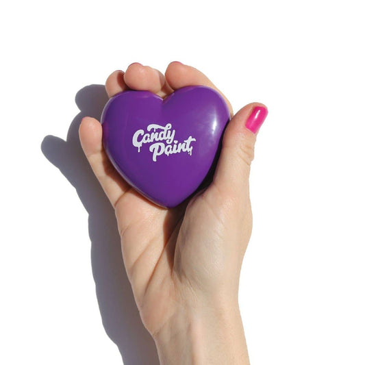 Hand holding purple heart-shaped cream bronzer for face compact from Innovate the Label