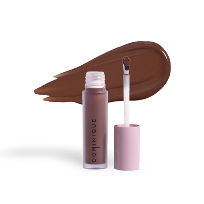 Dominique Cosmetics concealer in brown shade with doe-foot applicator and color swatch behind
