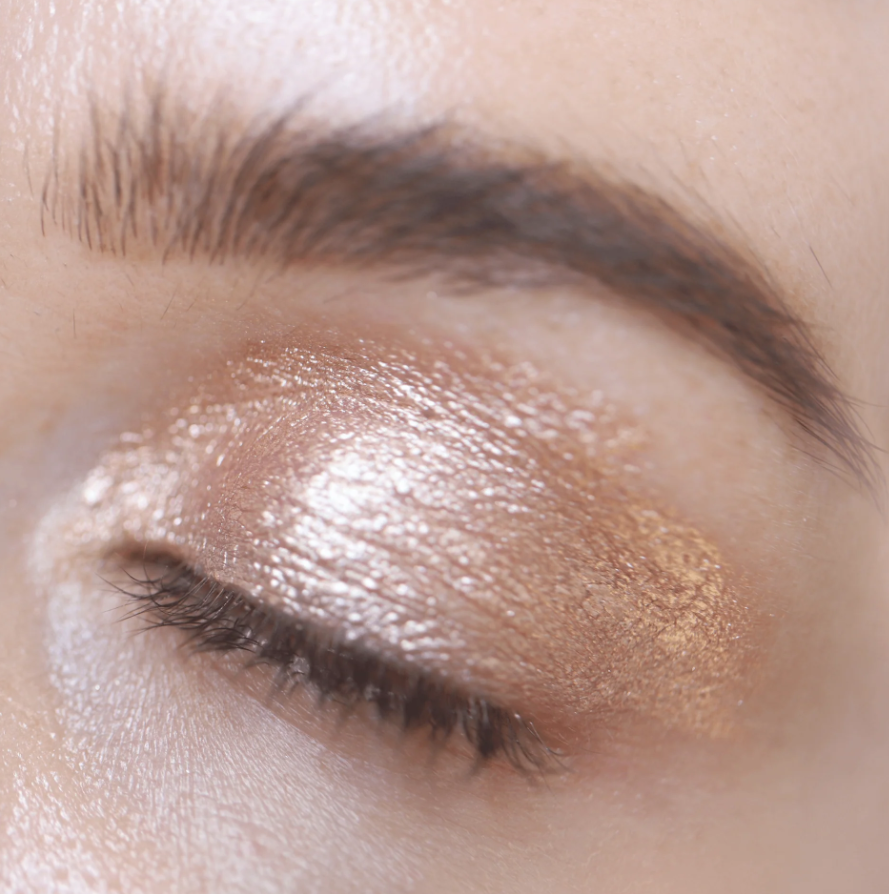 Eye close-up with shimmering rose gold eyeshadow applied using Half Caked Night Show Liquid Shadow