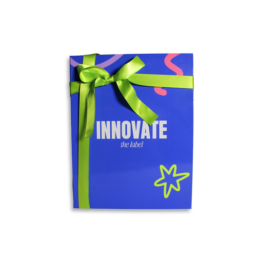 Innovate the Label beauty bundle gift box in blue with green ribbon and colorful design accents