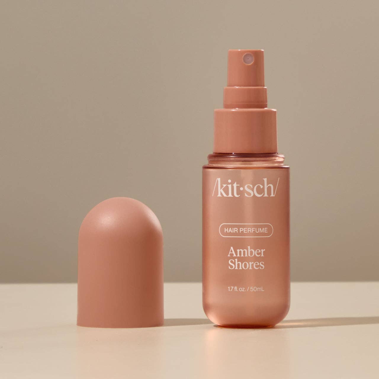 Innovate the Label amber hair perfume in sleek amber bottle with spray nozzle and cap on neutral surface