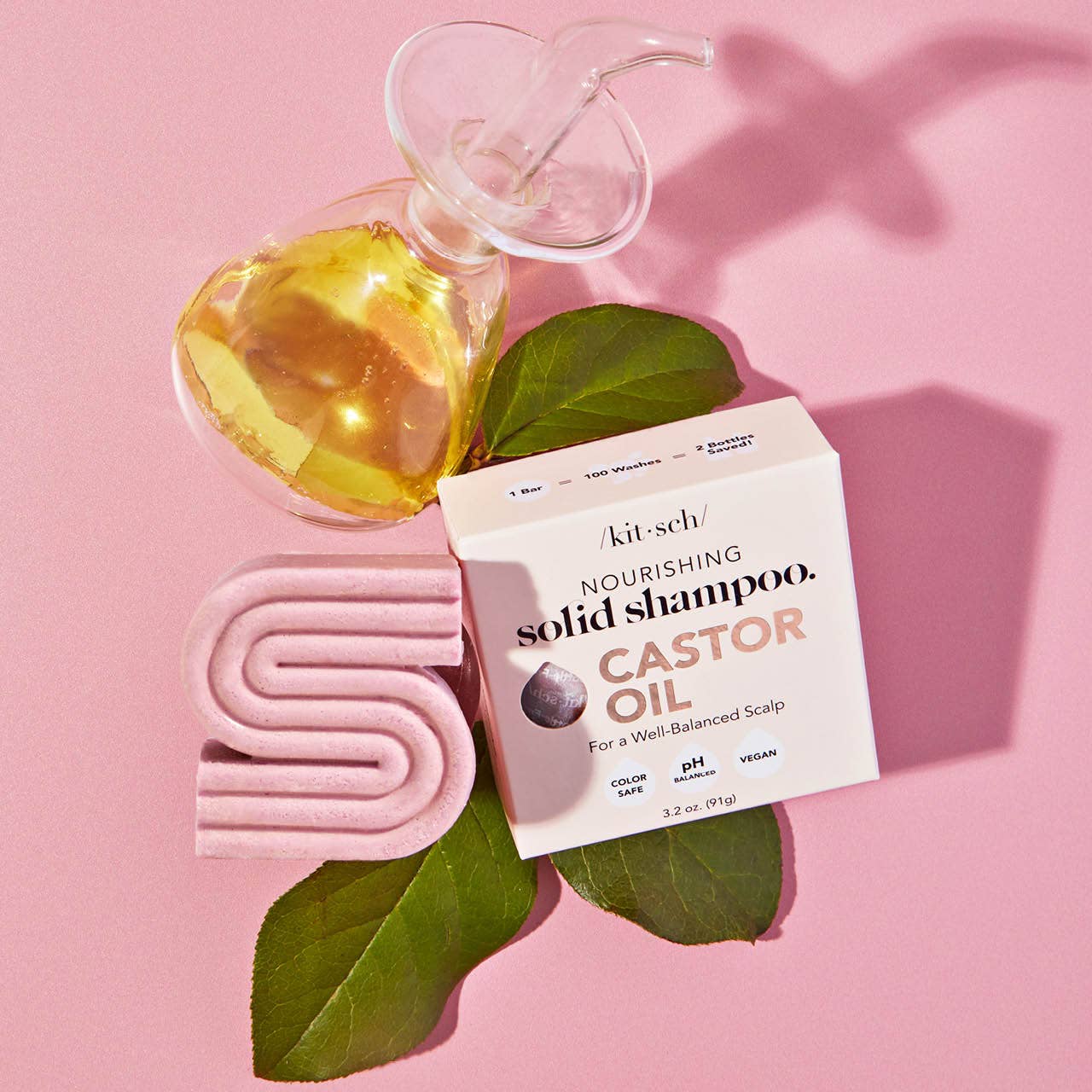 Innovate the Label castor oil shampoo bar solid shampoo with natural castor oil and green leaves on pink background