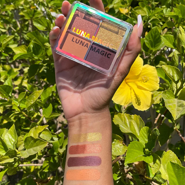 Luna Magic Desert Heat Eyeshadow Quad held above arm showing four swatches in warm desert tones