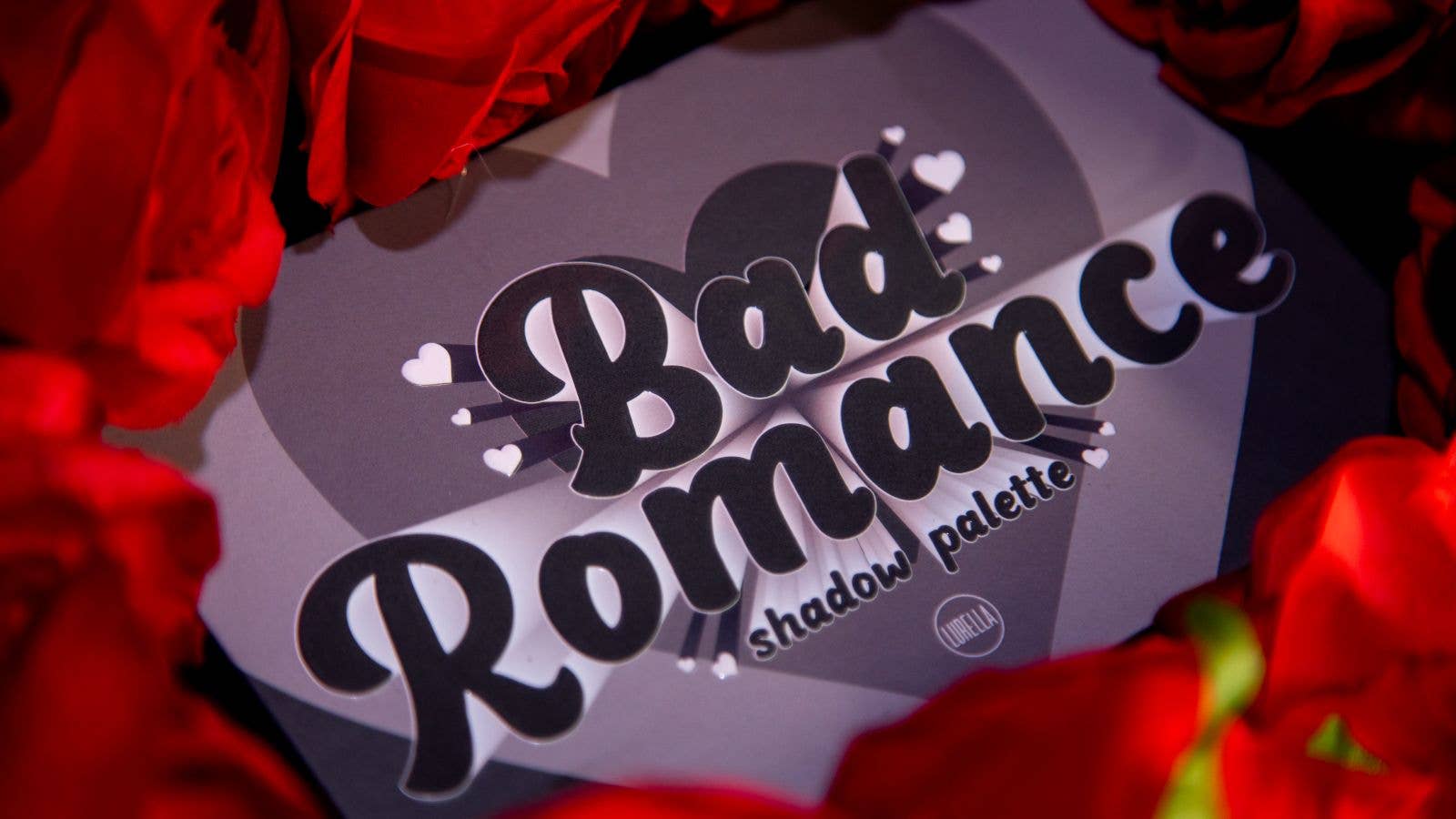 Lurella Bad Romance eyeshadow palette packaging surrounded by red roses from Innovate the Label