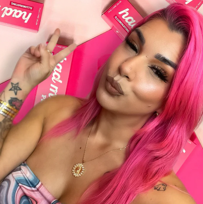 Woman with pink hair showing glowing skin using Innovate the Label illuminating face primer