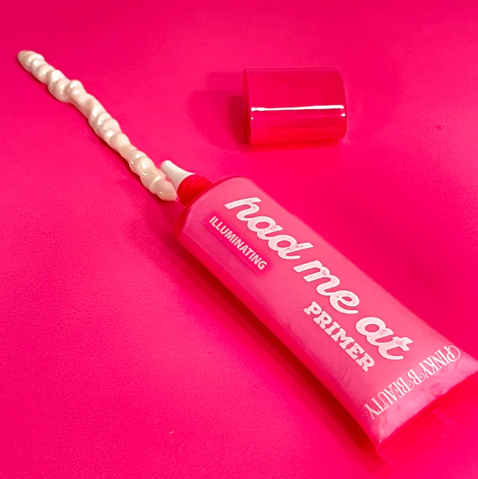 Innovate the Label illuminating face primer tube with a cream applicator on bright pink background
