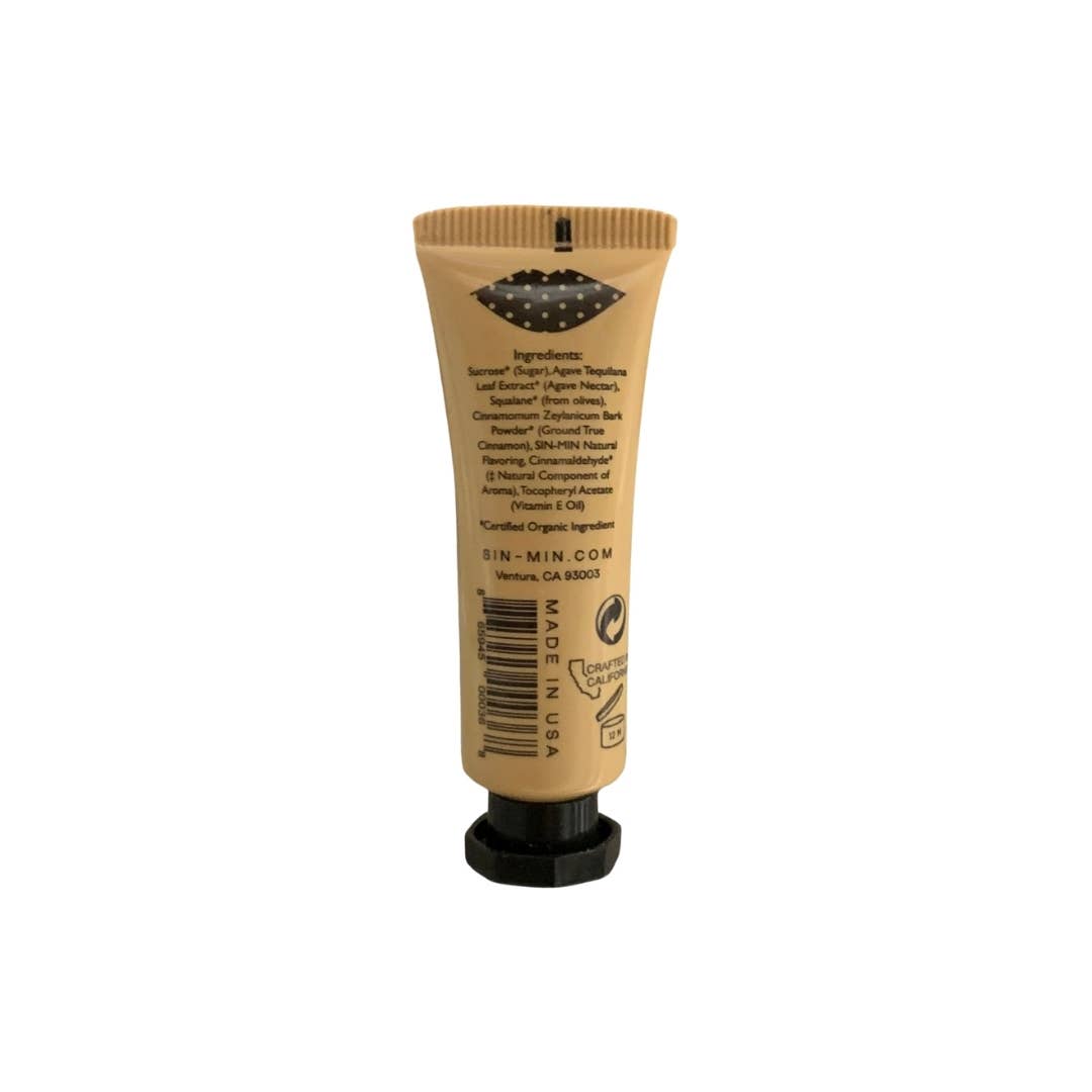 SIN-MIN vegan lip scrub in a small beige squeeze tube with black cap showing back ingredients label