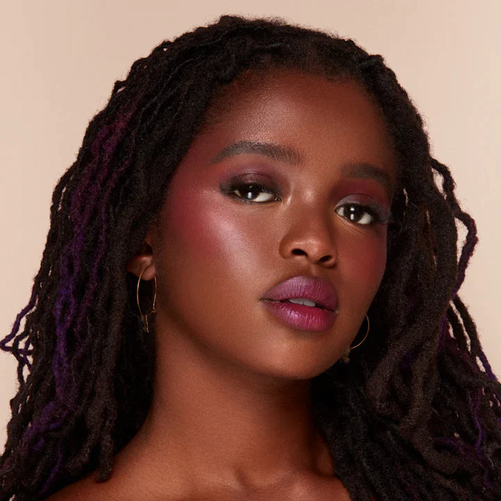 Close-up of woman wearing Alamar liquid blush with deep pink tones on cheeks and matching lipstick